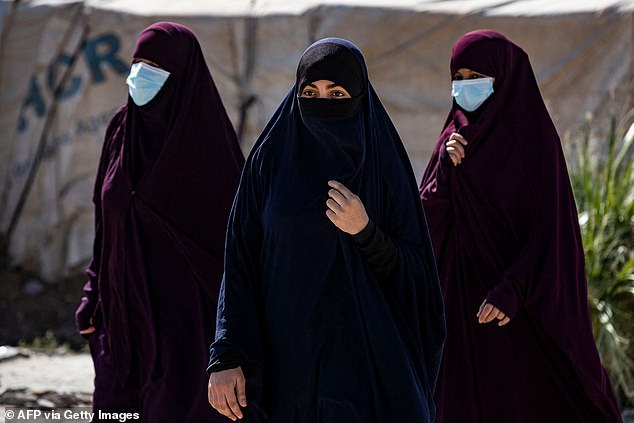 Women walk at Camp al-Roj, where relatives of people suspected of belonging to the Islamic State (IS) group are held, in the countryside near al-Malikiyah (Derik) in Syria's northeastern Hasakah province on October 8, 2023