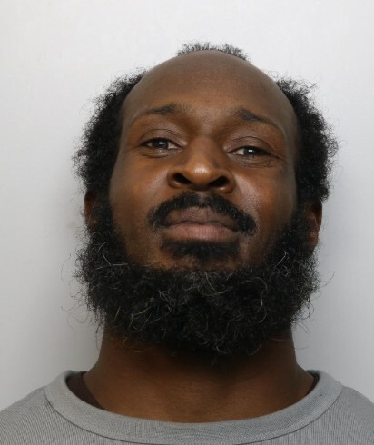 Mugshot of Craig Anderson, an adult male with dark skin, a receding hairline, and a dark beard, looking directly at the camera with a neutral expression.