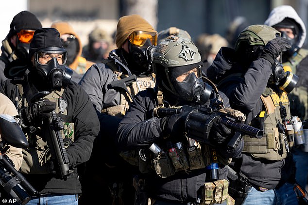 Federal agents point weapons at protesters near the site of the fatal shooting of 37-year-old Alex Pretti by federal agents in Minneapolis on Saturday
