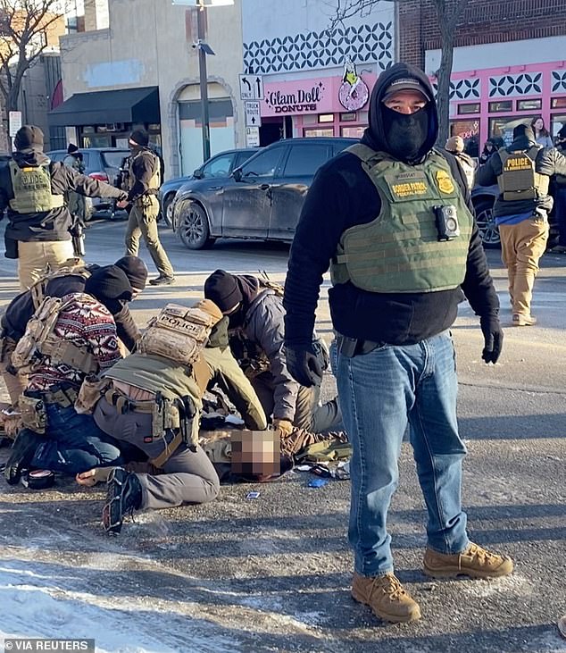 Law enforcement officers kneeling next to the body of Pretti, who was fatally shot when federal agents tried to detain him in Minneapolis, Minnesota, on Saturday