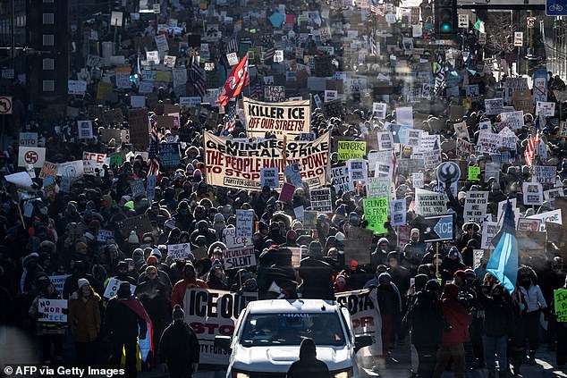 Protestors are seen above marching through the streets of downtown Minneapolis after Pretti's death