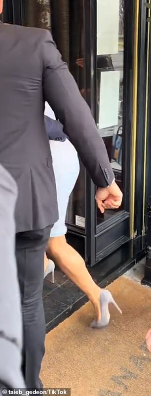 She was navigating in pointed-toe pumps and waving to photographers when her heel caught on the ledge of the entrance, prompting her to temporarily lose her footing