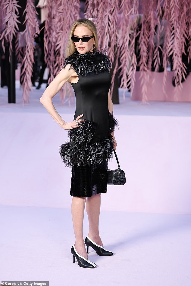 Actress Nicole, 58, turned heads in a quirky black feathered mini and dark shades as she made her arrival and posed for the cameras