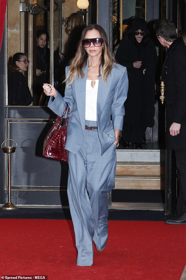 She added a red belt to her look to match the bag and completed the outfit with a low-cut white top