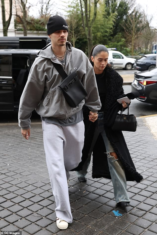 Kim opted for a black coat and ripped jeans as she stepped out with Romeo