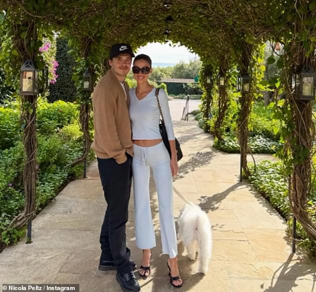 Despite the family heartache, Brooklyn smiled for the camera as he posed for a snap with Nicola