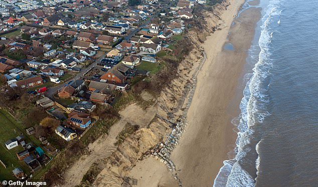 In this aerial view properties stand next to rapidly eroding cliffs, on January 19, 2026 in Hemsby, England