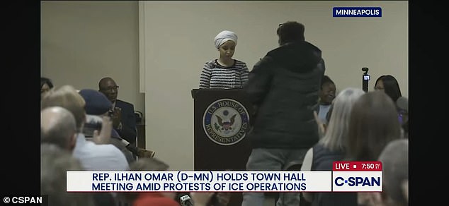 The protester ran toward Omar and sprayed a mystery substance at her from a syringe. He then told Omar to resign and claimed she's 'tearing Minnesota apart' before being dragged away by security guards