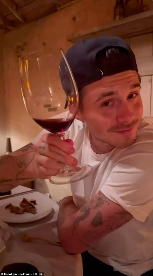 Brooklyn holds a glass of red wine as he poses for a photo at the San Ysidro Ranch in Montecito