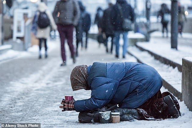A Romanian woman begs in Southwark in London, during icy winter conditions