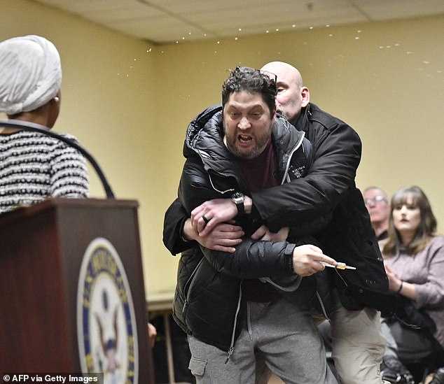 Kazmierczak is pulled away by security after he allegedly used a syringe to squirt a strong, vinegar-like-smelling liquid at Rep. Ilhan Omar during a Minneapolis town hall Tuesday night