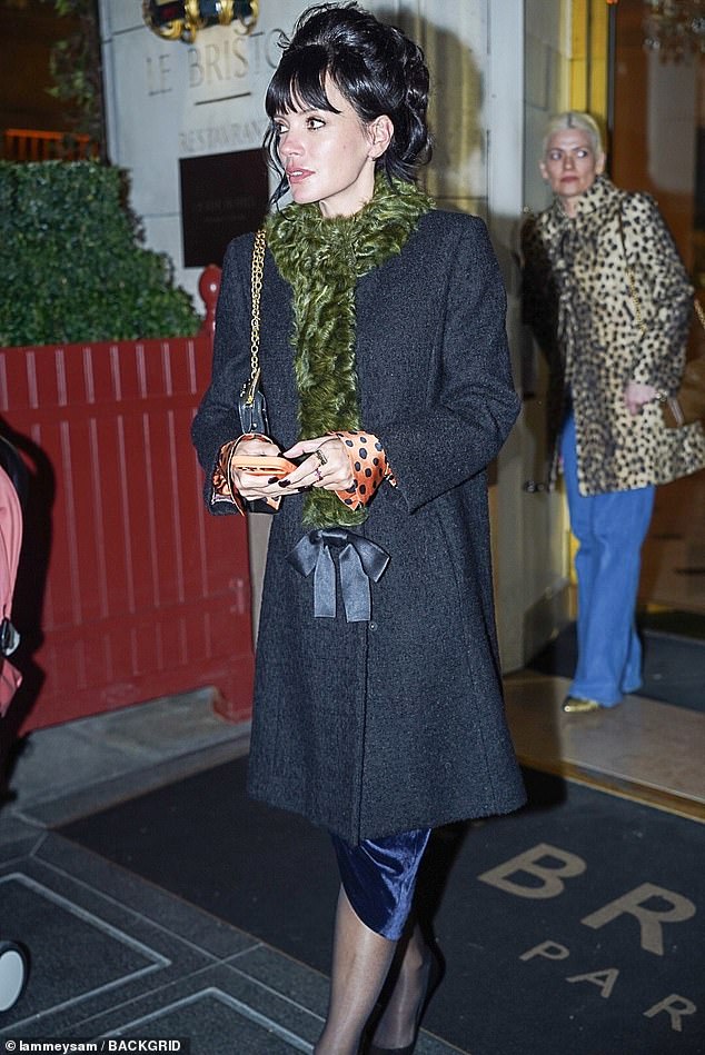 Lily opted for a grey coat with a green fur scarf for the party, with her signature black hair up in a beehive style