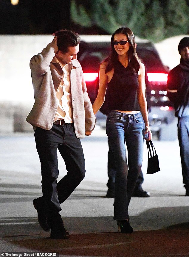 Dressed in a white shirt, jeans and a light brown jacket, Brooklyn cut a casual figure