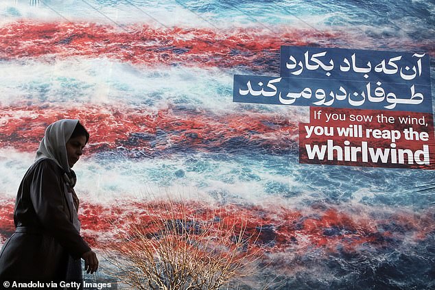 A woman walks past a propaganda poster condemning the US in Tehran this week