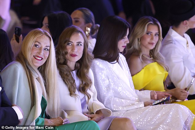 Jerry looked glamorous for the evening in a striking turquoise satin jumpsuit, paired with a matching tied waistband blazer