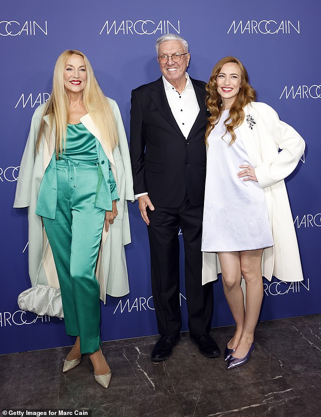 Elizabeth paired the A-line dress with a white longline coat and lilac accessories, including a fringed handbag and metallic stilettos (pictured with Helmut Schlotterer)