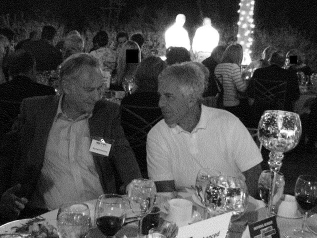 The disgraced financier chatting to a man at a glitzy dinner on an unknown date