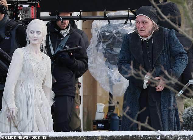 The Hollywood star looked almost unrecognisable in his full Victorian get-up as he cracked a smile between takes alongside Andrea Riseborough, who plays the Ghost of Christmas Past