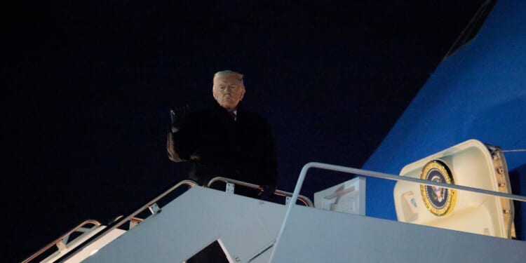 President Donald Trump gestures as he boards Air Force One as he leaves Washington for Switzerland on Jan. 20, 2026, in Joint Base Andrews, Maryland.