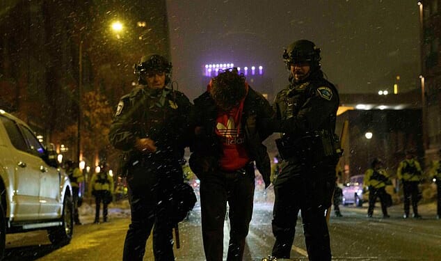 An anti-ICE protester is arrested during a late night protest in Minneapolis