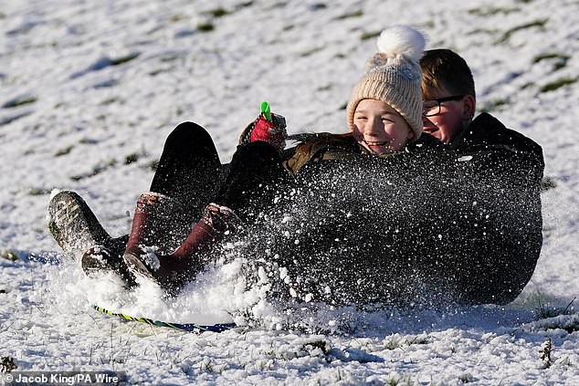 Siblings Eva and Nate sledge down the hills at Burton Dassett Hills Country Park in Warwickshir
