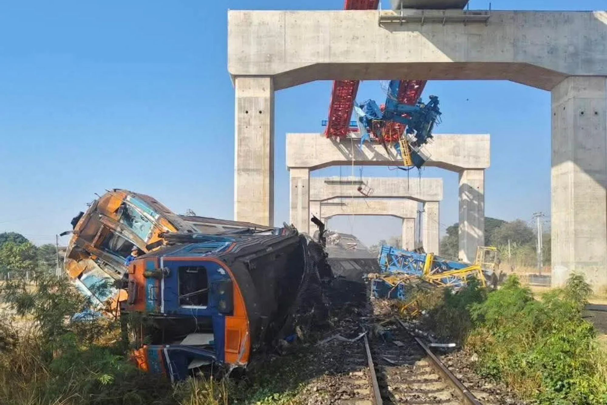 An image collage containing 1 images, Image 1 shows A train derailed after a crane fell onto its carriage in Sikhio district, Nakhon Ratchasima province, Thailand