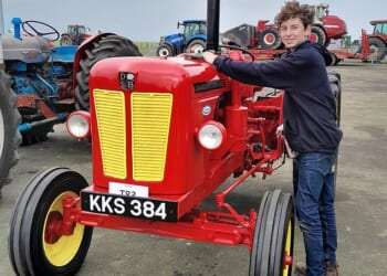 Alex cleans the newly-restored tractor