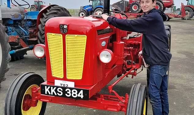 Alex cleans the newly-restored tractor