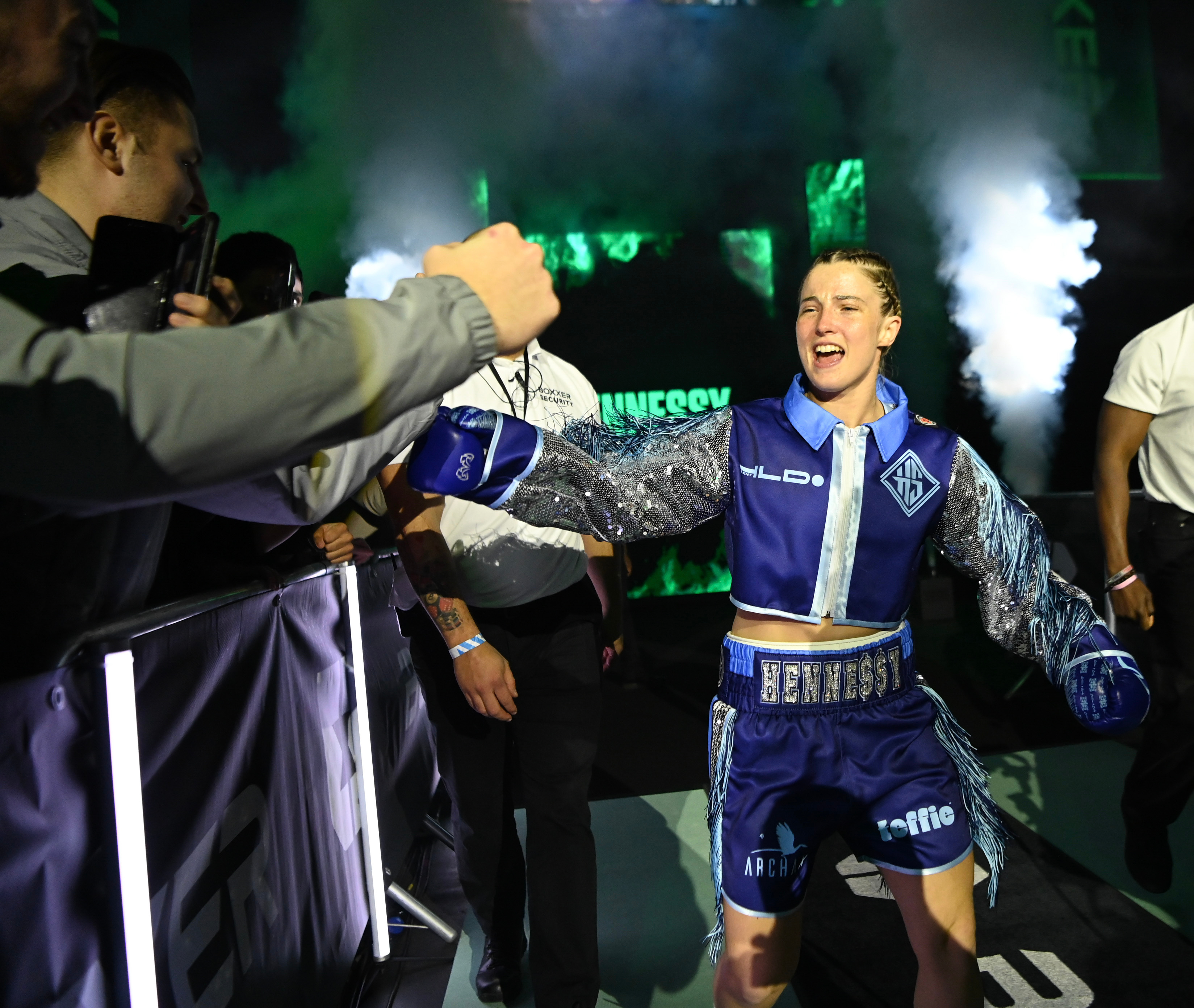 Boxer Jessica Hennessy high-fives a fan while entering the ring.