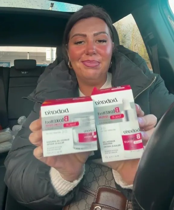 A woman in a car holds up two boxes of Bioxelan skincare products.