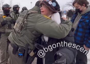 An unidentified federal agent and a woman hugged at a protest after having a conversation about being veterans