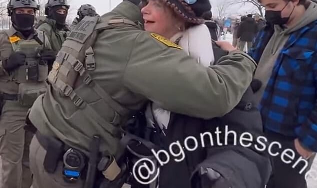 An unidentified federal agent and a woman hugged at a protest after having a conversation about being veterans