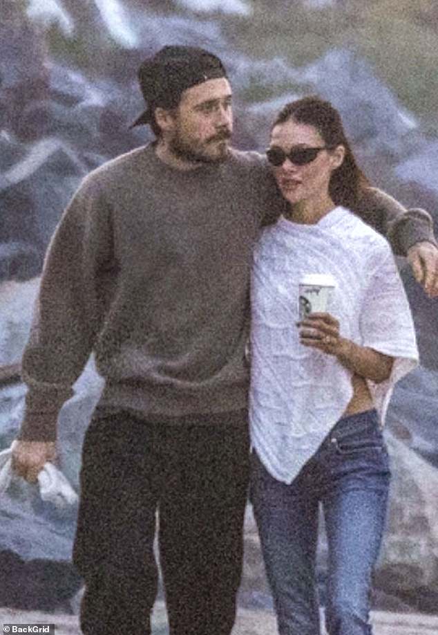 Brooklyn carried a dog lead in one hand and wrapped his other arm around Nicola