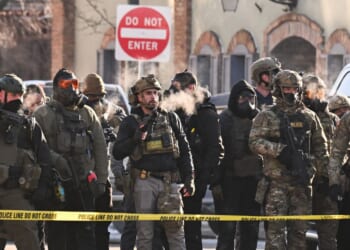 Federal agents stand behind police tape as demonstrators gather near the site of where state and local authorities say a man was shot by federal agents earlier in the morning in Minneapolis, Minnesota, on Jan. 24, 2026.
