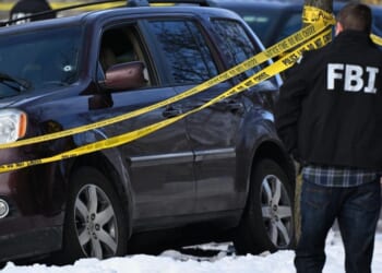 A bullet hole is seen in a windshield Wednesday as law enforcement officers attend to the scene of the shooting involving federal law enforcement agents in Minneapolis.