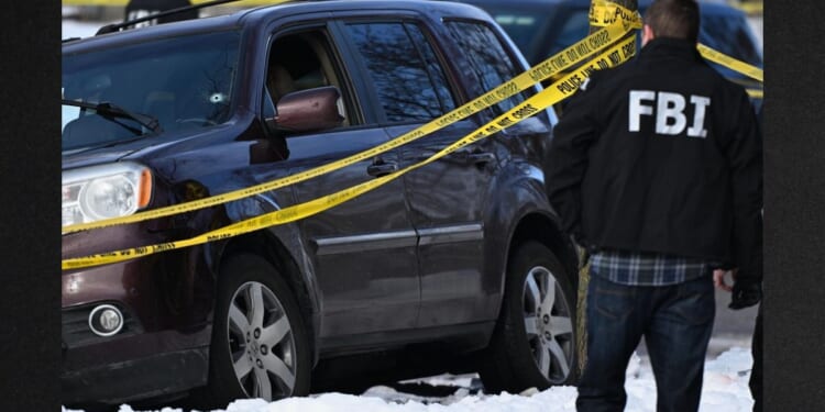 A bullet hole is seen in a windshield Wednesday as law enforcement officers attend to the scene of the shooting involving federal law enforcement agents in Minneapolis.