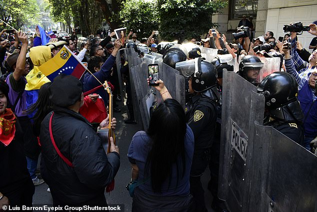 Riot police prevent protesters from reaching the US embassy during a demonstration against the United States government for the detention of Venezuelan President Nicolás Maduro and his wife, Cilia Flores