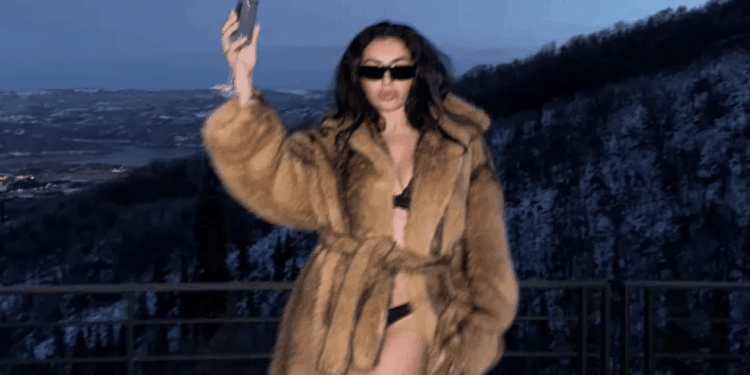 Charli XCX strips off to nothing but lingerie and a fur coat as she braves freezing temperatures at film festival