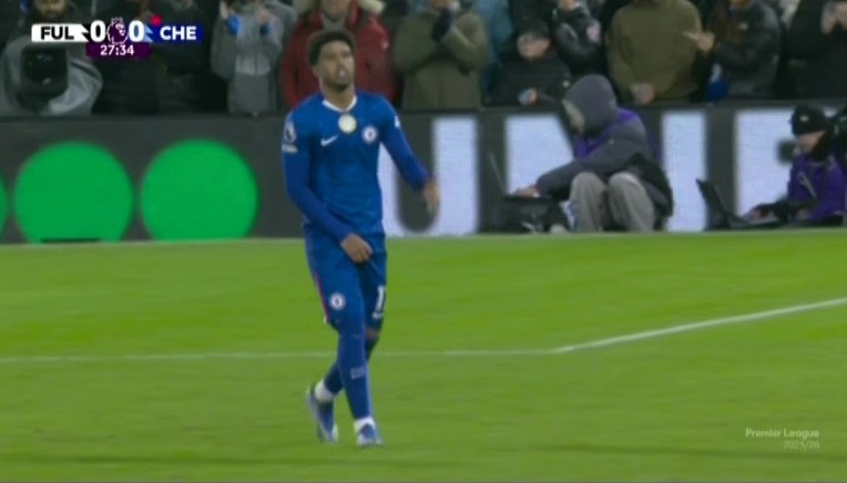 A football player in a blue uniform on a green field.