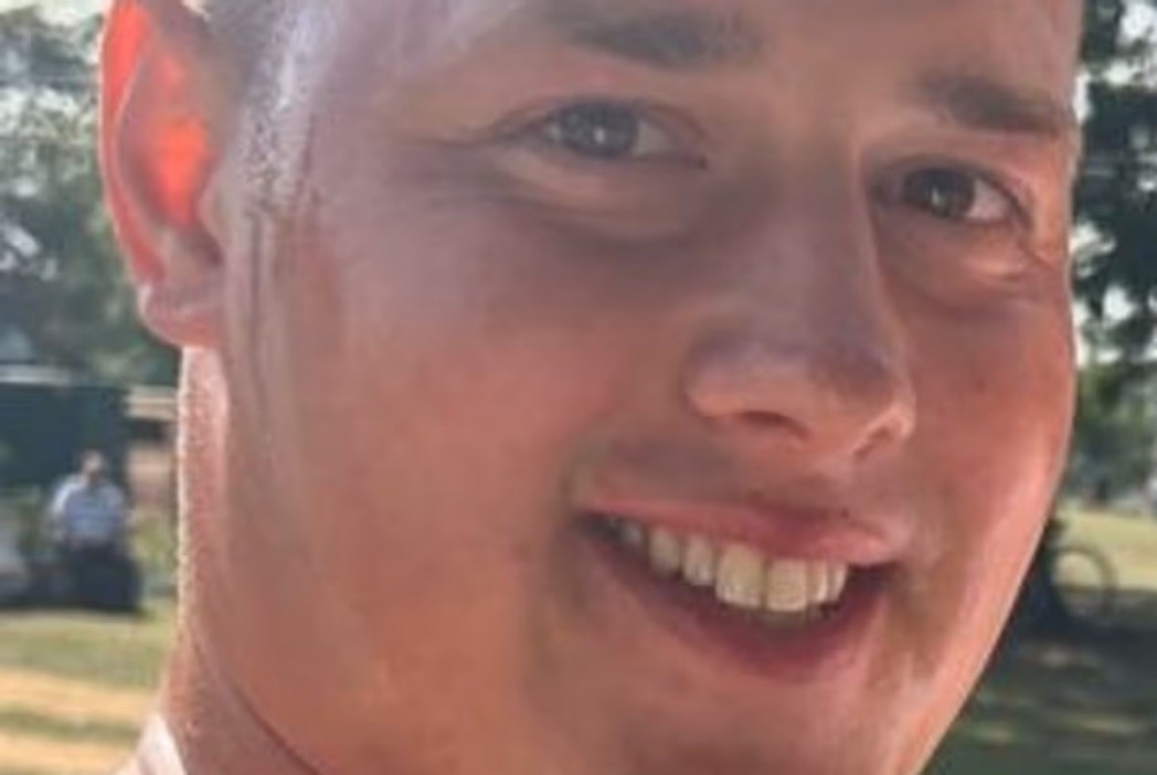 A close-up of a young man smiling.