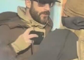 Alex Jeffrey Pretti, 37, could be seen the street filming with his phone while a small group confronts a federal agent. His other hand appeared to be empty