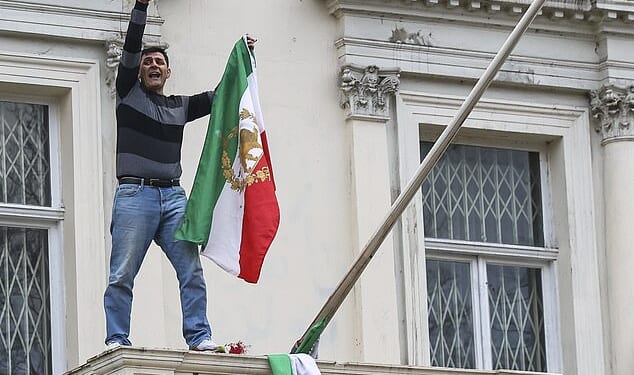 In London on Saturday a male protester was seen climbing onto the balcony of the Iranian embassy in Kensington and tearing down the flag of the current regime