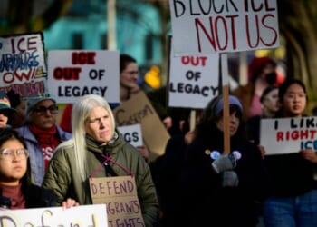 Anti-ICE activists display signs during a protest near Legacy Emanuel Hospital on Jan. 10, 2026, in Portland, Oregon.