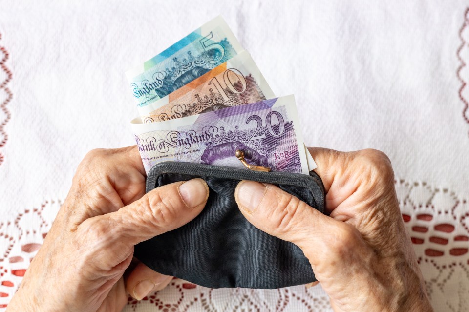 Worked hands of senior woman holding old fashioned ladies purse with British pounds. Economic concept, Financial situation of seniors in UK. Flat lay, close-up