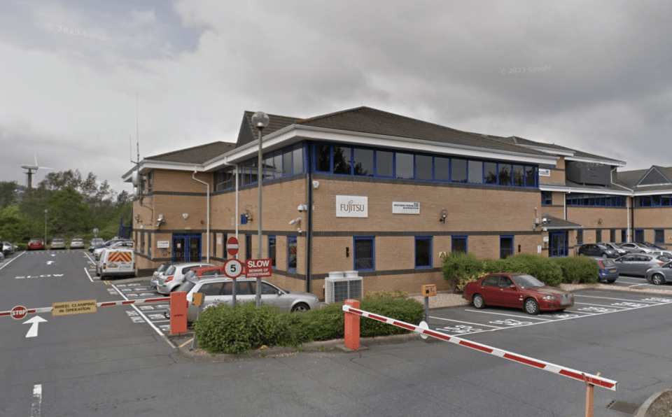 Exterior of a Fujitsu and Western Power Distribution office building with a parking lot.