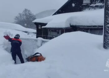 Entire buildings buried in MASSIVE snow drifts as mega blizzards kill at least two and locals forced to dig out of homes