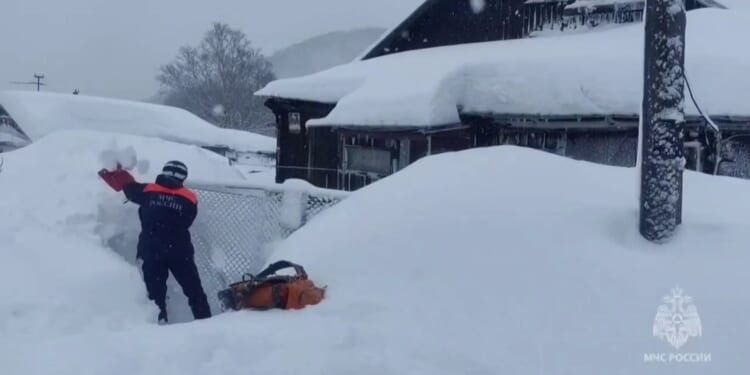 Entire buildings buried in MASSIVE snow drifts as mega blizzards kill at least two and locals forced to dig out of homes