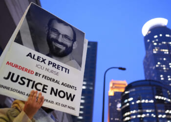A person holds a sign of Alex Pretti during a protest outside the office of Sen. Amy Klobuchar on Jan. 26, 2026, in Minneapolis, Minnesota.