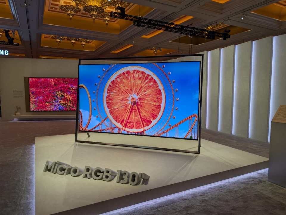 Large screen TV display with "Micro RGB 130" written on the platform in front.
