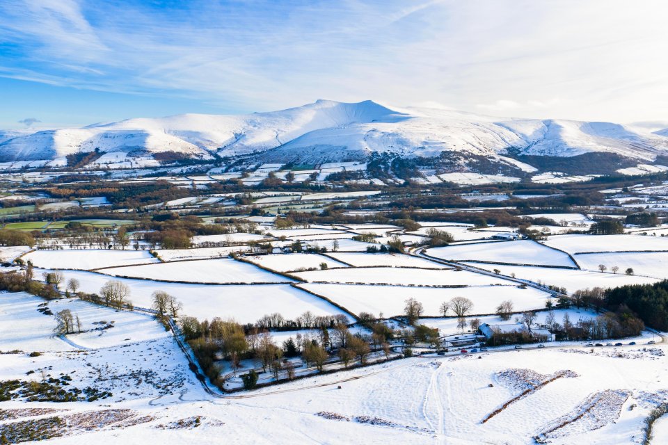 Brecon Beacons, Brecon, Wales, UK. 10th January 2026. UK Weather. Aerial view of the snow covered mountains of the Brecon Beacons (officially Bannau Brycheiniog National Park) showing the summit of Pen y Fan on a cold and sunny afternoon. Pictu